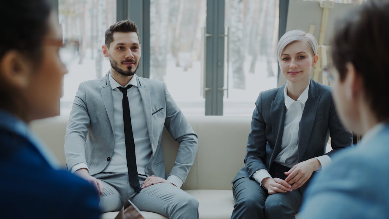 Business meeting with professionals in suits discussing in a modern office.